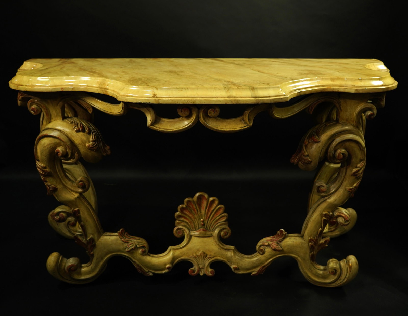 An Italian Rococo style painted wood console table: An Italian Rococo style painted wood console table, having a shaped faux marble top above the carved polychrome base, 33"h x 58"w x 24"d Provenance: Property from the Estate of Frank J. Caufield, San 