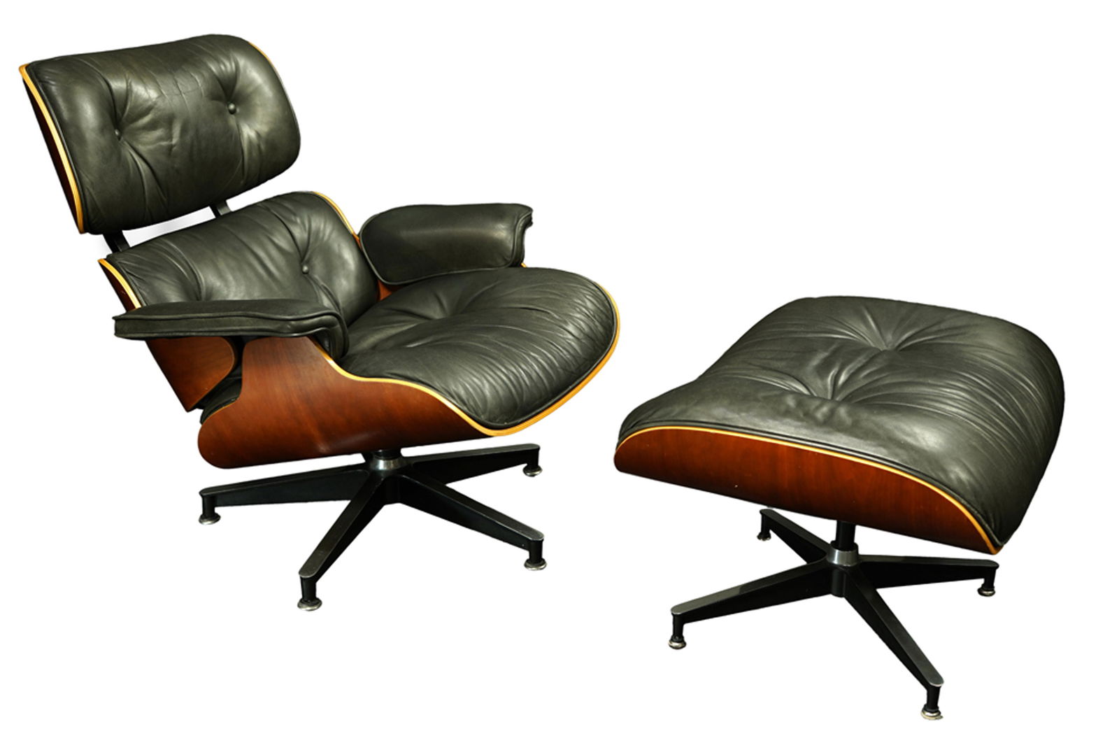 A Charles and Ray Eames for Herman Miller 670 and 671: A Charles and Ray Eames for Herman Miller 670 and 671 armchair and ottoman, executed in black leather with a molded walnut frame, the chair with Herman Miller label to underside, chair: 33"h x 33"w x
