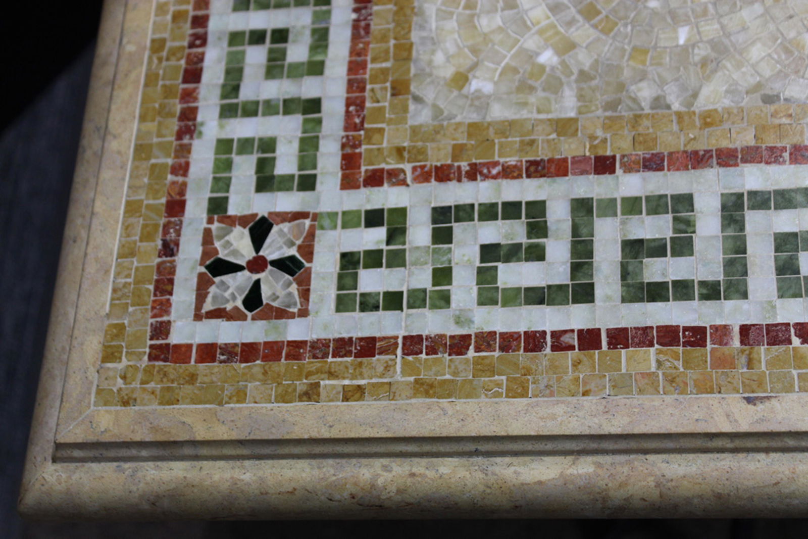 A custom mosaic top salon table in the Pompeiian taste: A custom mosaic top salon table in the Pompeiian taste, with a floral and Greek key border surrounding the diamond form medallion, and rising on wrought metal outswept legs, 30"h x 75"w x 44.5"d