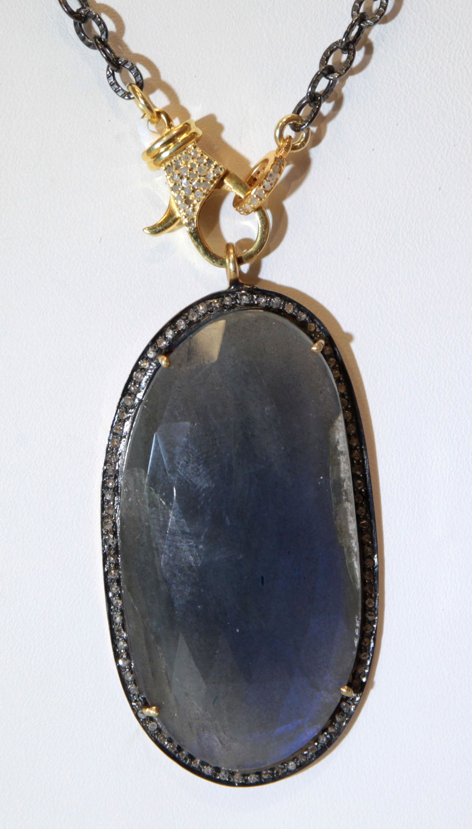 Labradorite, diamond, blackened and gilt silver: Labradorite, diamond, blackened and gilt silver pendant-necklace Featuring (1) faceted-topped, oval labradorite cabochon, measuring approximately 48 X 25 mm, accented by (numerous) round-cut diamonds,