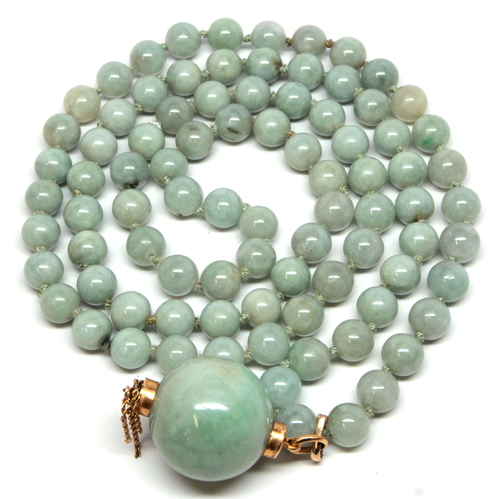 Jadeite, yellow gold necklace: Jadeite, yellow gold necklace Composed of (89) jadeite beads, ranging in size from approximately 9.5 mm to 10.0 mm, suspending (1), 27 mm, jadeite bead, capped in 18k and 14k yellow gold with (5) rope