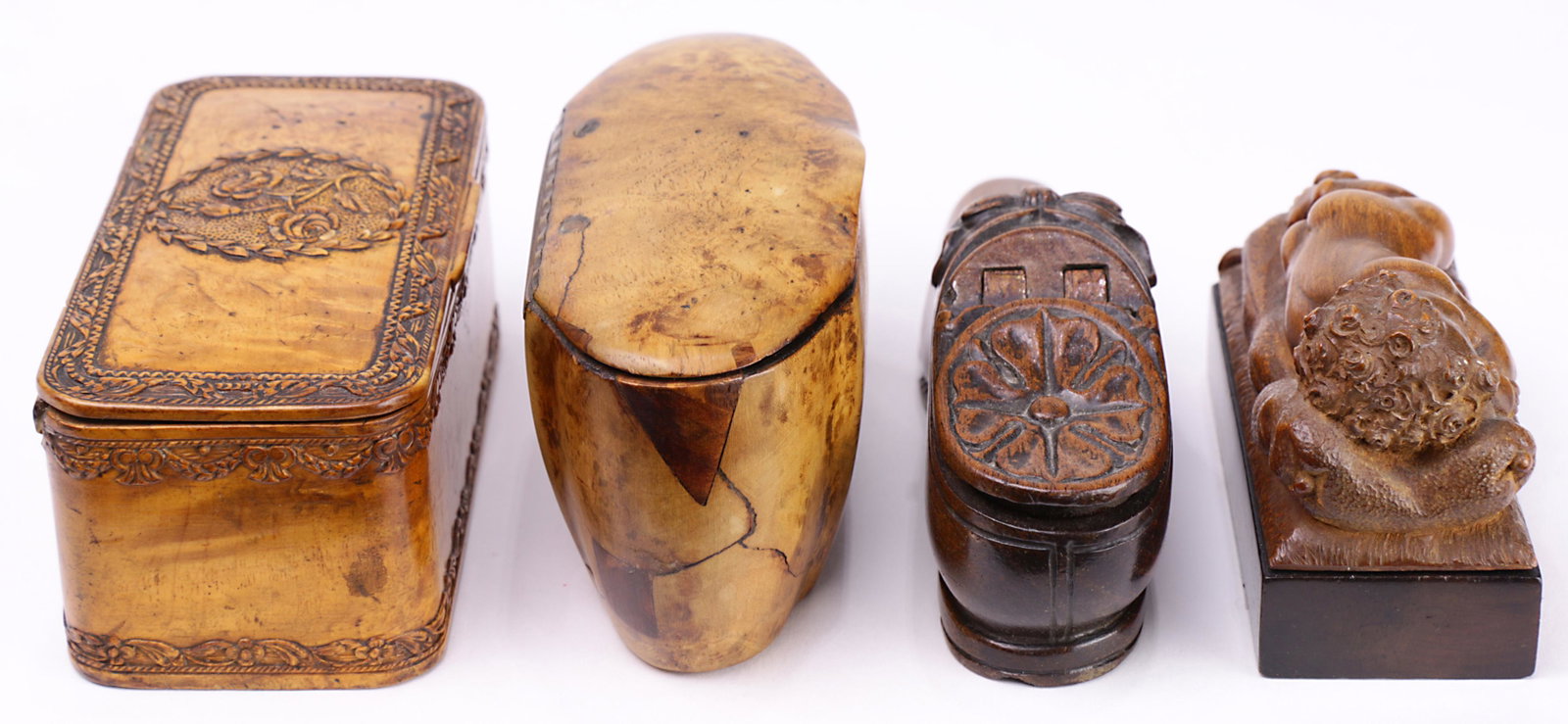 (lot of 4) A group of continental carved snuff boxes: (lot of 4) A group of continental carved snuff boxes circa 1870, two of figural form, one a shoe with a hinged lid, and one a sleeping cherub having a sliding lid, two having a hinged lid, largest 2"h