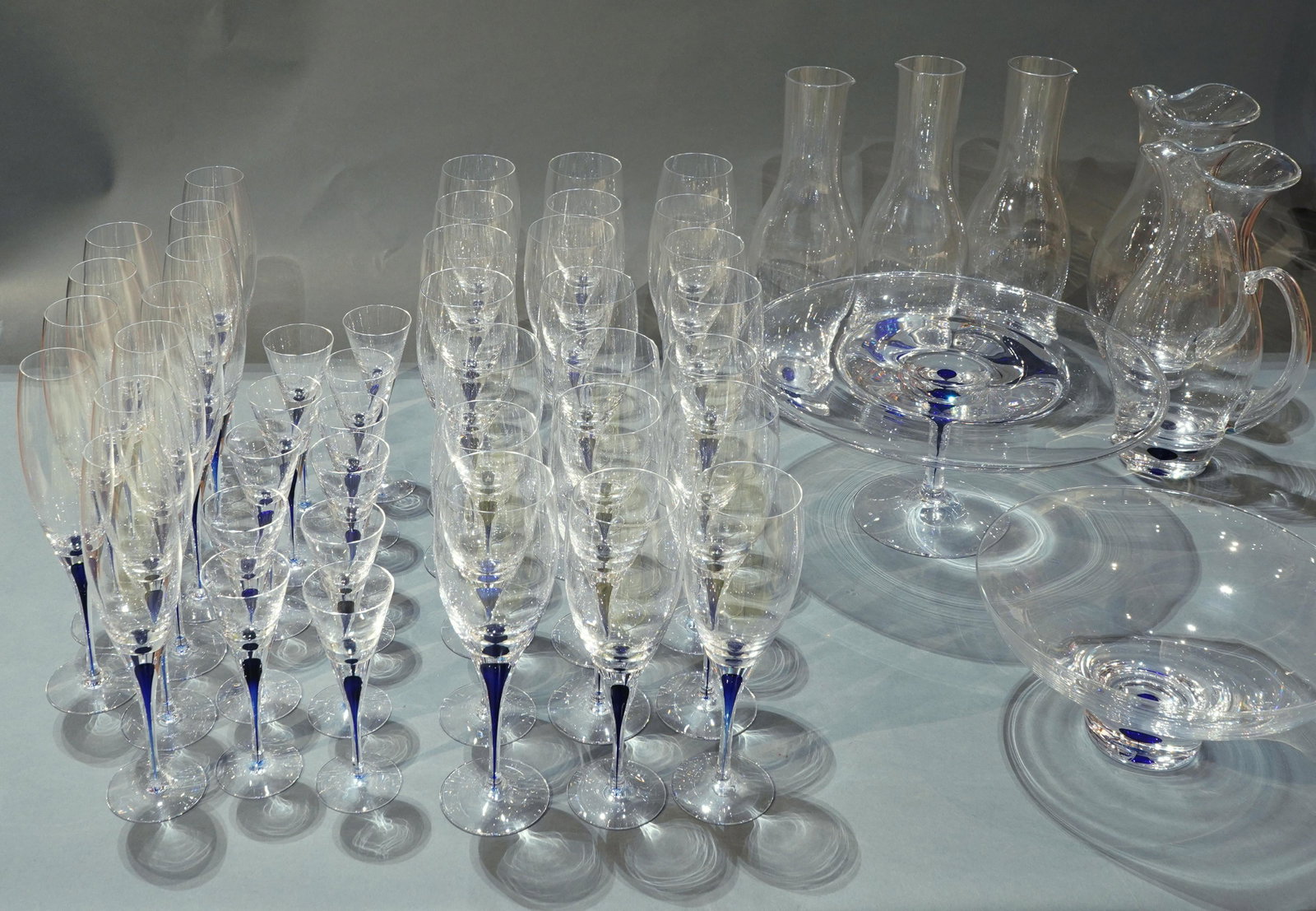 A Large set of Orrefors Intermezzo blue stemware: (lot of 50) A large set of Orrefors Intermezzo blue stemware, designed by Erika Lagerbielke in 1985, each stem having a cased blue drop, consisting of (11) cordials, (11) champagne flutes, (21) wine g