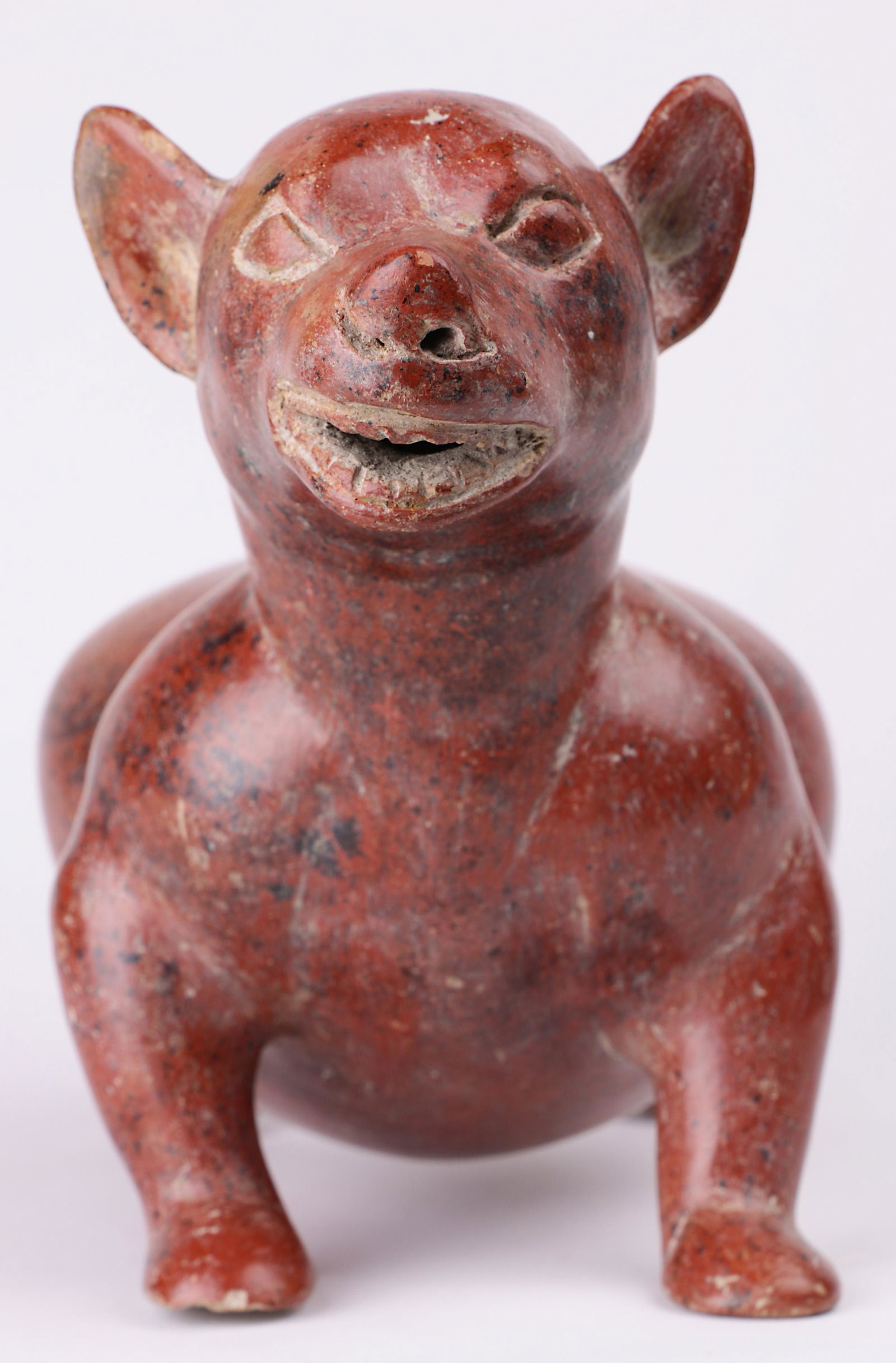 A Pre-Columbian Colima, West Mexico, dog, Ex Ron: A Pre-Columbian Colima, West Mexico, small redware dog, 200BC-300AD, depicted at attention, with teeth exposed and having a stout posture, 7.5"h x 10"l Provenance: Ex prominent Woodside CA estate, Ex