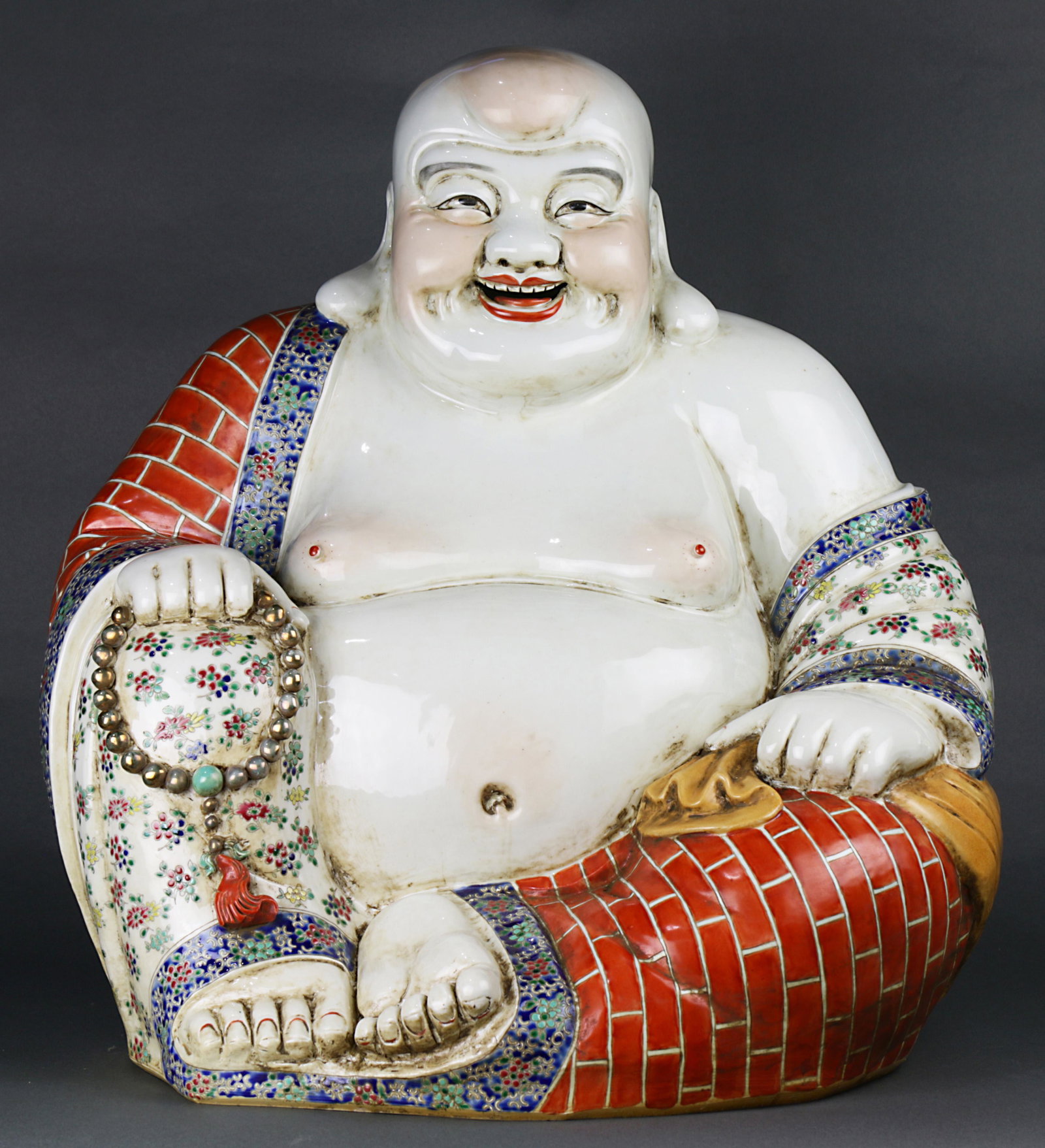 A large Chinese Famille Rose Figure oF Budai: A large Chinese Famille Rose Figure oF Budai , modelled wearing open robes, the monk potted with realistic folds of skin, holding prayer beads in his right hand and a sack in the left, the base bearin