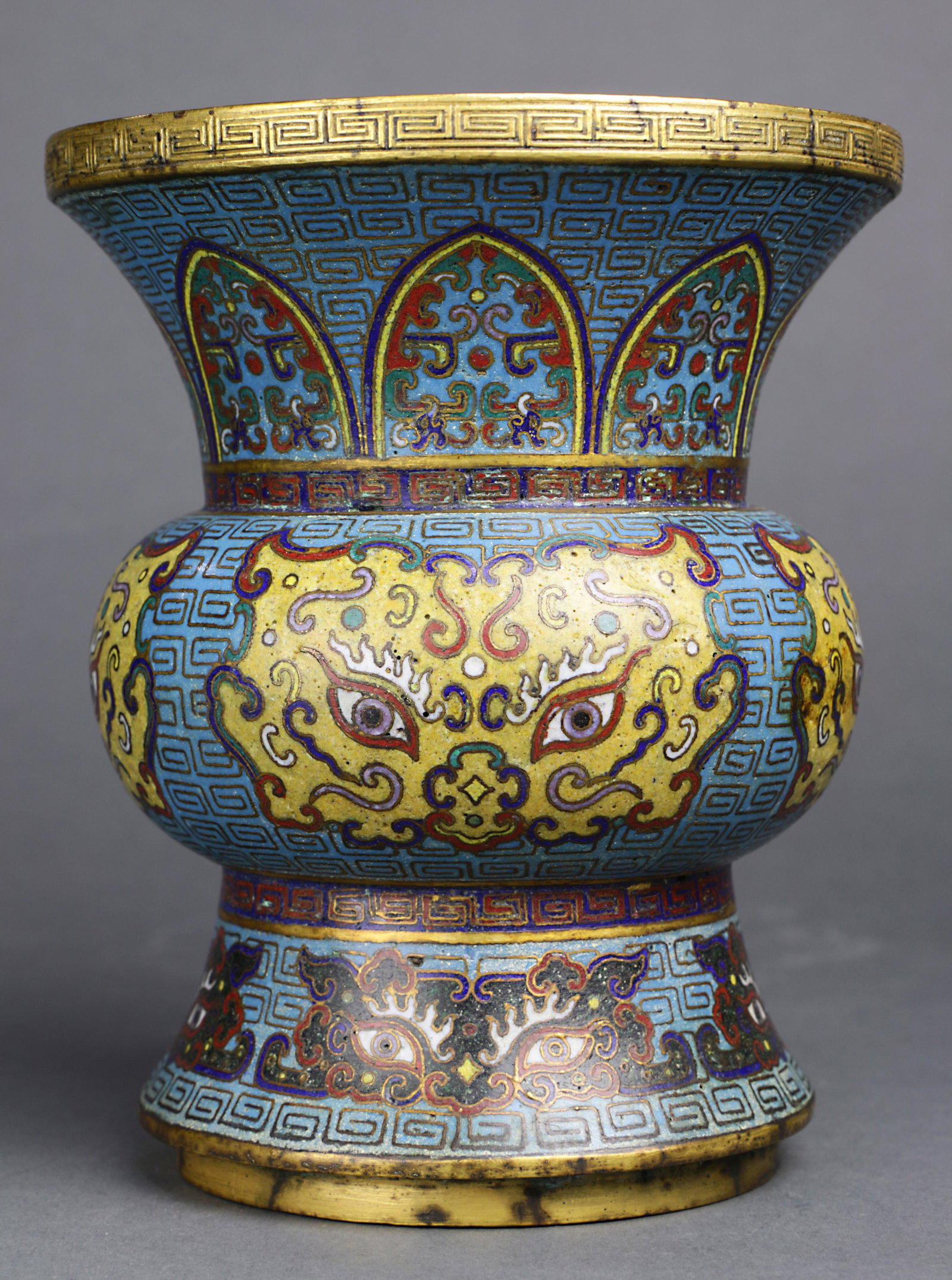 A Chinese Gilt-Bronze and Cloisonne enamel "Taotie": A Chinese Gilt-Bronze and Cloisonne enamel "Taotie", spittoon, Zhadou, with a compressed globular body rising from a conical foot to a flaring trumpet mouth, the body decorated with Taotie patterns le