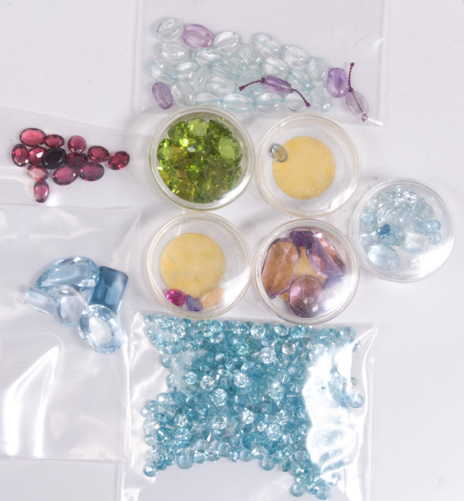 Collection of unmounted multi-stones: Collection of unmounted multi-stones Including (numerous) unmounted round-cut blue zircons, weighing 153.53 cts.; (18) unmounted round, square and triangular-cut peridots, weighing 37.73 cts.; (13) un