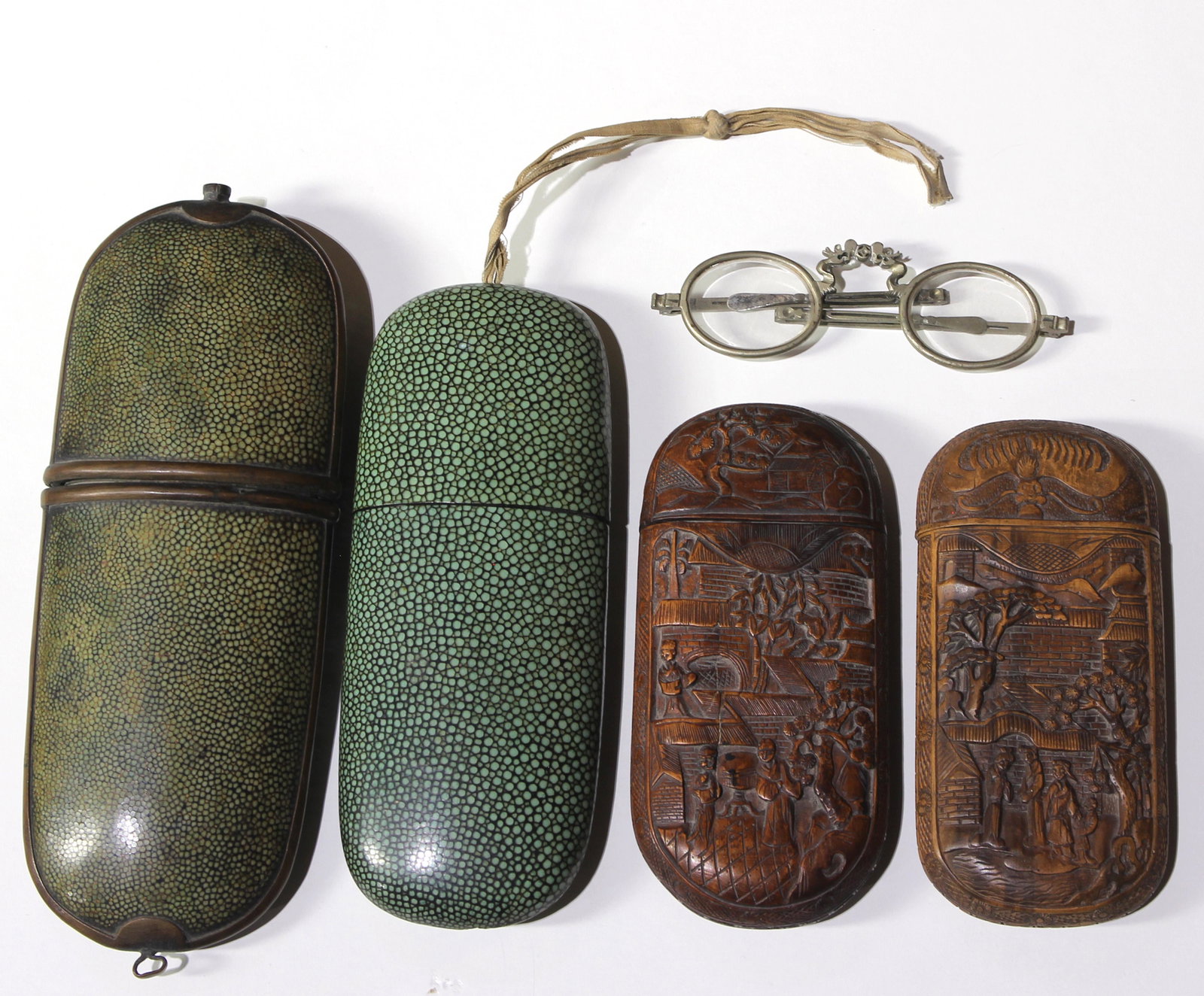 (lot of 5) A Chinese eyeglass case group: (lot of 5) A Chinese eyeglass case group, comprising a pair of green tinted shagreen eyeglass cases, largest 8"l x 3"w, en suite with a pair of spectacles; together with a pair of carved boxwood cases