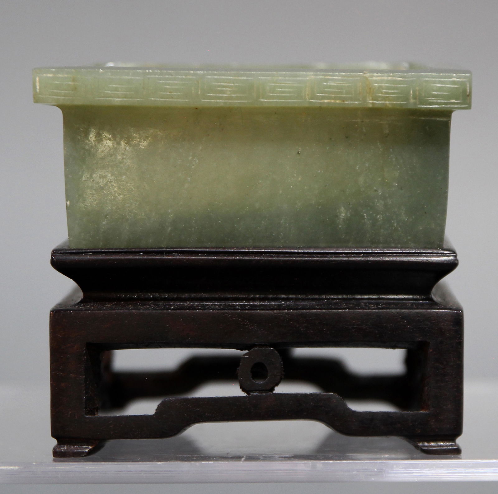Chinese nephrite square planter: Chinese nephrite square planter, in the Archaistic style, the square dish with an outset fretwork border, carved from a pale green stone specimen, en suite with a hardwood table form stand, dimensions
