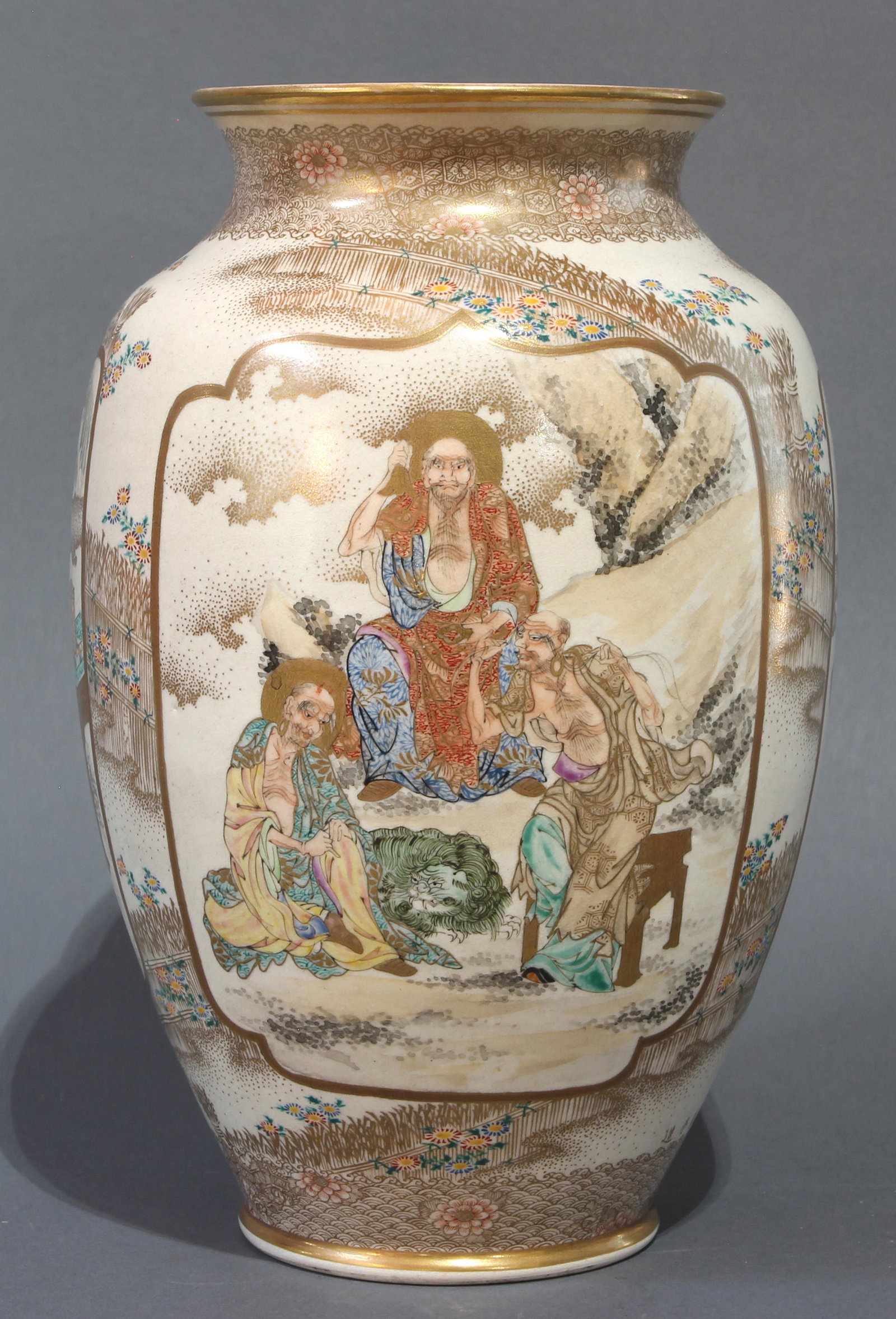 Satsuma vase: Satsuma vase, Kozan, the ovoid form continuously decorated with figural medallions of the Buddhist triad; scholars viewing a scroll and two warriors, reserved against gilt and enameled fenced garden r