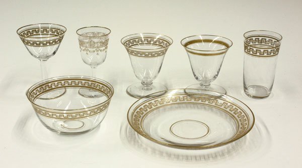 Glassware gilt design glasses plates: (lot of 56) Glass set with gilt Greek freize design at trim; 16 martini glasses, 8 liquor/dessert cups, 9 juice cups, 6 desert, 4 plates, 8 fruit bowls, and 6 sherries