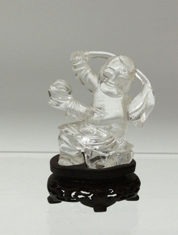 Chinese Rock Crystal Carving, Boy: Chinese rock crystal figural carving, depicting a boy kneeling with a large lotus bud on a stalk in his right hand, the other holding a jewel, the transparent matrix with opalescent inclusions, with a