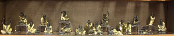 (18) Chinese Gilt-Bronze Lohans/Arhats: (lot of 18) Chinese gilt and patinated bronze lohans, each of the Buddhist sages portrayed in his characteristic pose, four standing, three with their animal companions, five seated on rockwork, the r