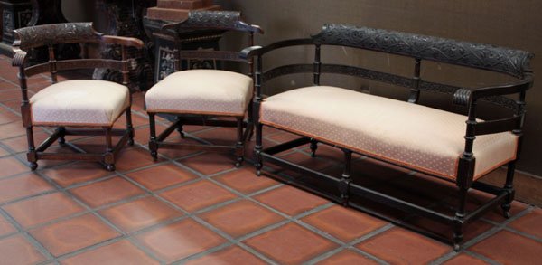 Parlor suite settee and chairs: (lot of 3) Parlor suite including settee, 28''h x 51''w x 26''d, having ebonized wood frame with floral relief carvings, turned supports, paw form arm ends, patterned peach fabric upholstery with tang