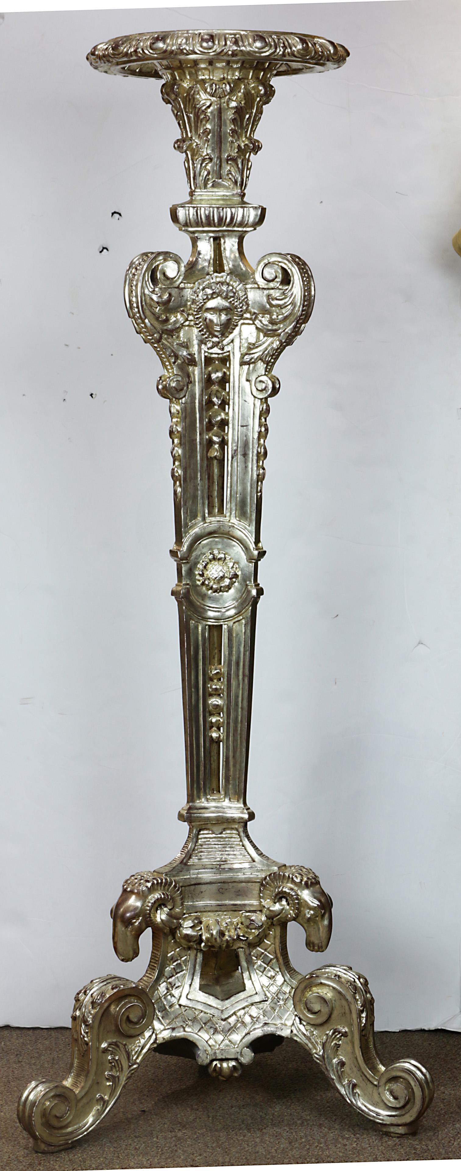 A Classical style silvered plant stand: Classical style silvered wood plant stand, having a circular top, above the pedestal base centered with a medallion of a face, and rising on a tripod base with rams head mounts, 63"h