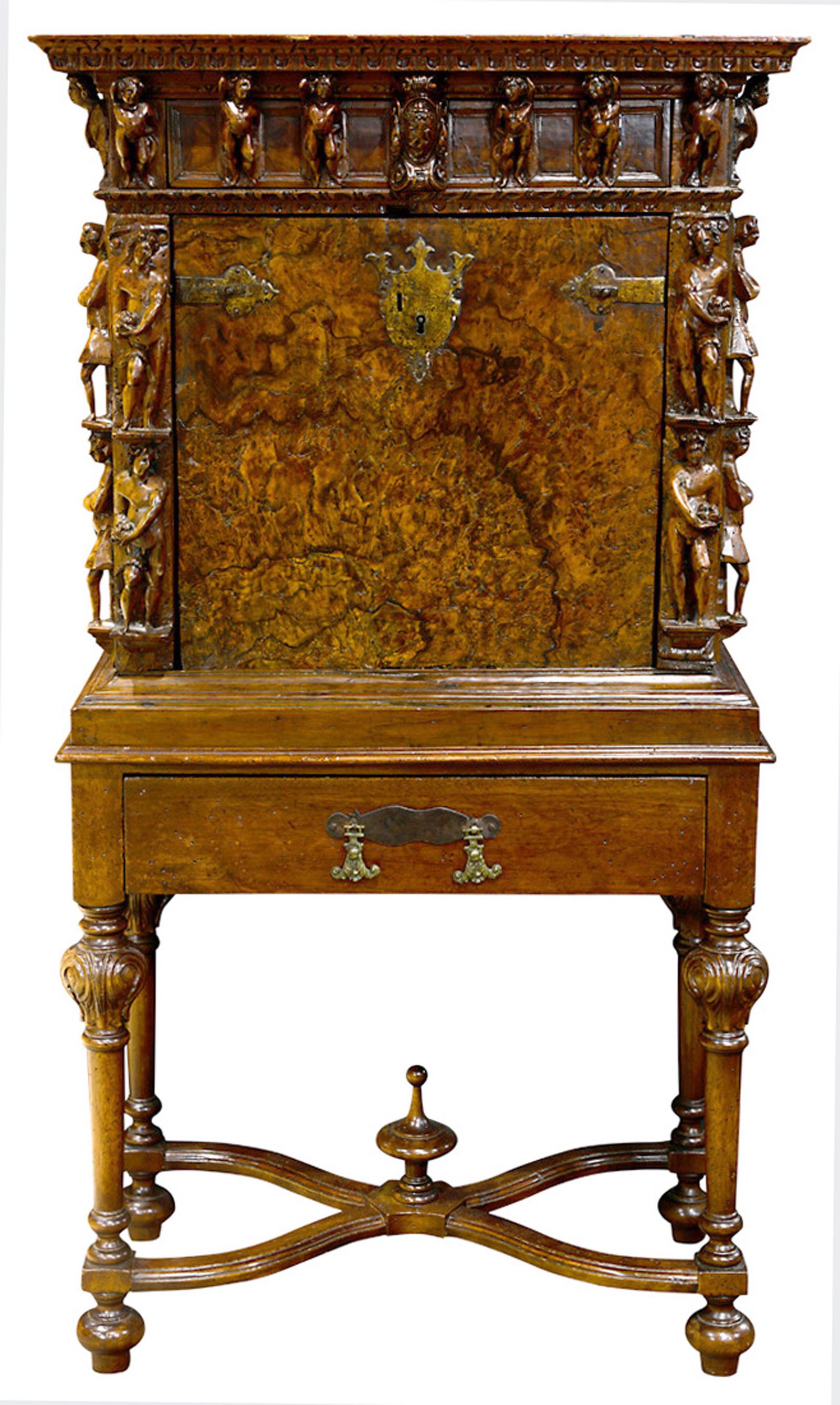 An Italian Baroque walnut collector's cabinet on stand: Italian Baroque highly carved walnut collector's cabinet on stand, having a rectangular molded top, above a slant front opening to a seven drawer case, centered with a figural carved door, flanked wit