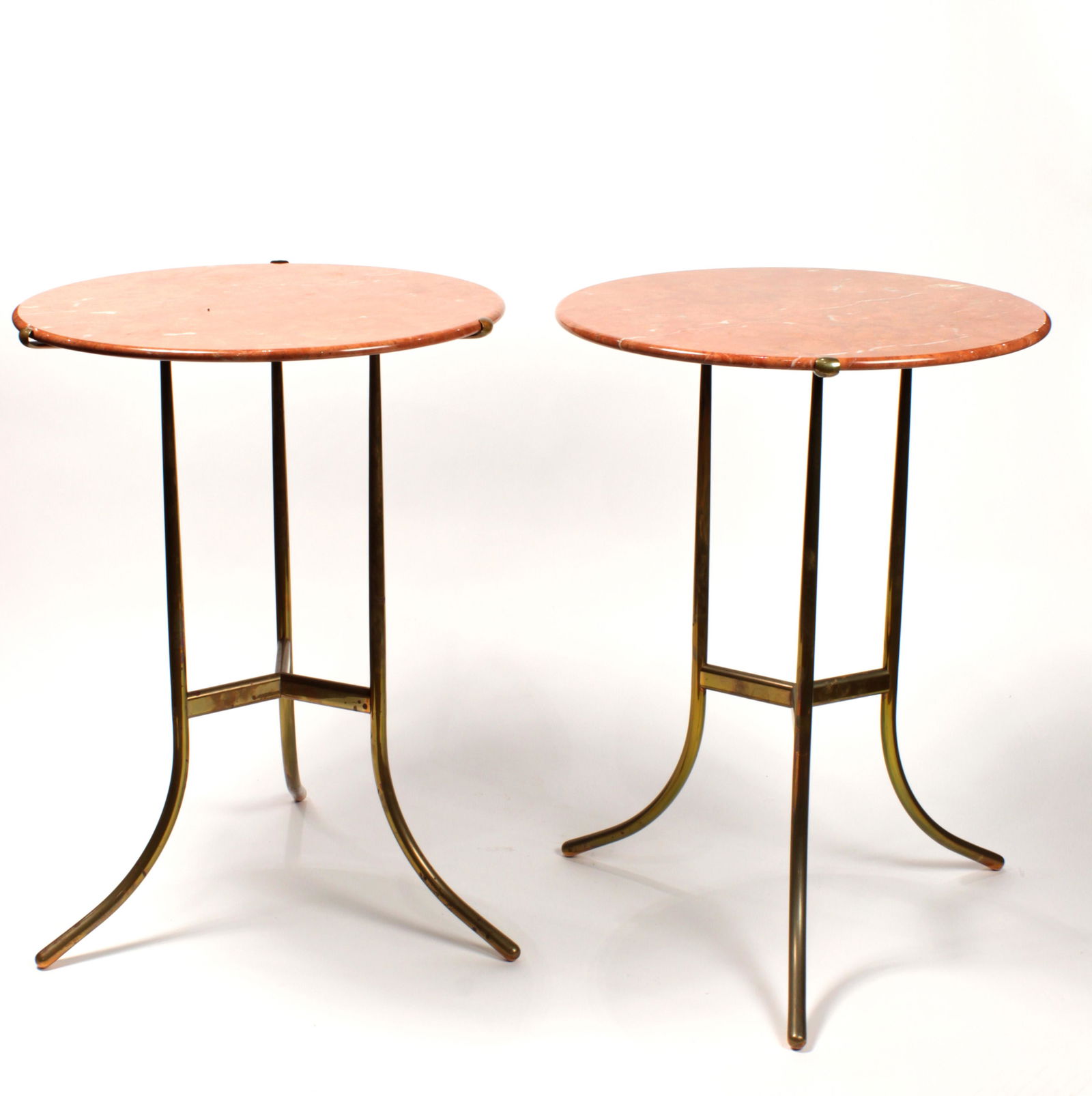 A pair of Cedric Hartman occastional tables: A pair of Cedric Hartman occasional tables, each having a variegated marble top, above a brass base, signed with impressed manufacturer's mark to underside of each example, 23"h x 17"dia.