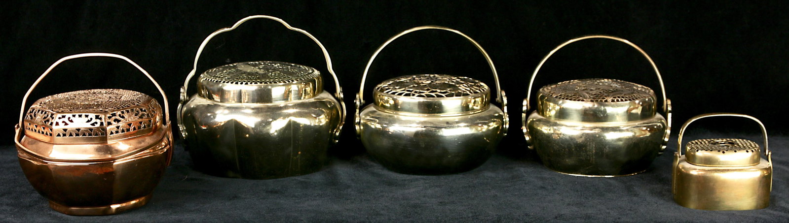A lot of (5) Chinese patinated metal handwarmers: A lot of (5) Chinese patinated metal handwarmers, each of compressed ovoid form, three of a high polish silver patination with perforated tops including one with bat, flowers, and Shou medallion; a se