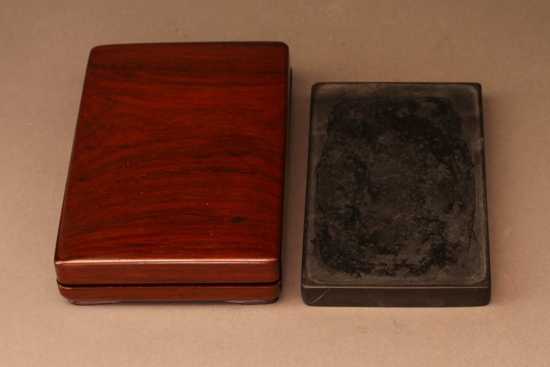 A Chinese Rectangular Poetry Inkstone: A Chinese Rectangular Poetry Inkstone, is carved with a smoothly polished grinding surface, the reverse incised with a Chinese poetry of 'Lan Ting Xu', with wood box. Dimensions: 0.62"h x 3.93"w x 6.3