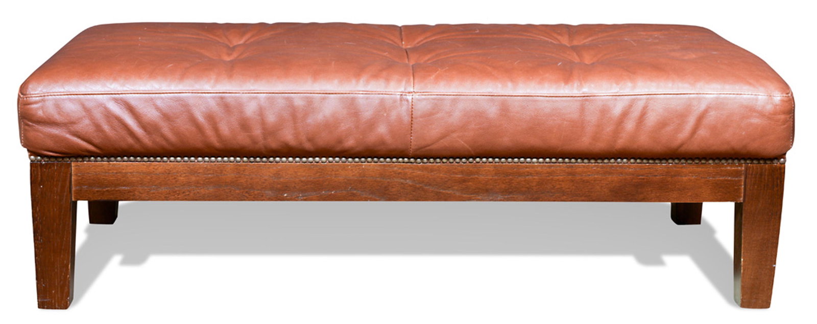 A Brown leather ottoman: A Moderne brown leather ottoman, having a rectangular top, above tapered legs, 15.5"h x 48"w x 22"d
