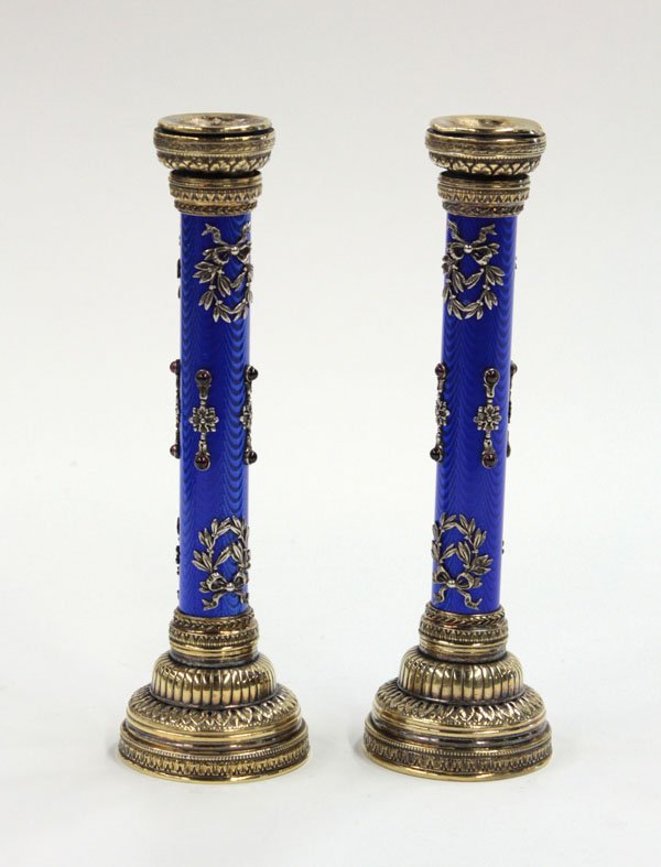 blue guilloche enameled candlesticks: Pair of blue guilloche enameled candlesticks, partial gilt gadrooned capitols and bases, the guilloche enameled stems mounted with applied floral motif silver castings with cabochon garnets. Bears hal