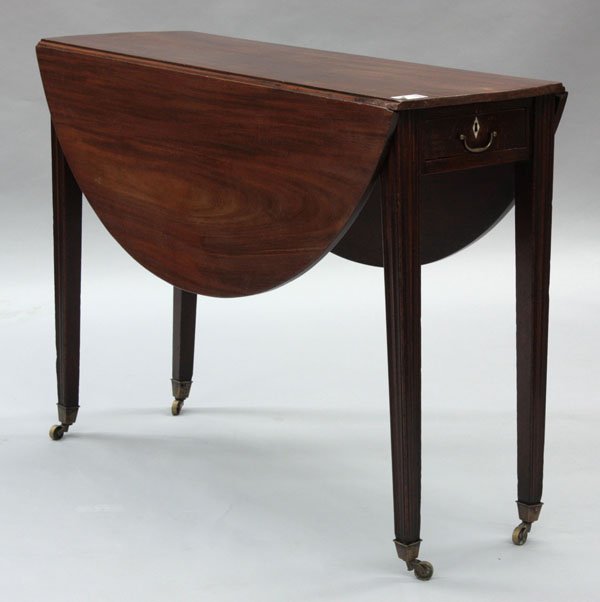Georgian Chippendale style table: Georgian Chippendale style narrow drop-leaf mahogany table, circa 1780, extends to circular top, over frieze drawer with ivory escutcheon, rising on swing fluted and tapered leg base, 29''h x 41''w x 