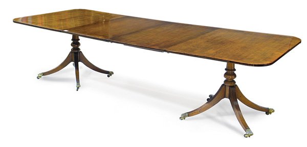 George III mahogany dining table: George III mahogany and crossbanded twin pedestal dining table, circa 1810, each pedestal with four reeded downswept legs ending in cast brass box castors, two leaves extend the table to 10'
