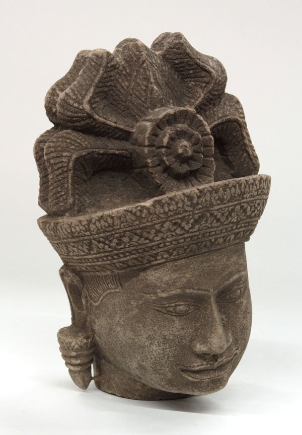 Southeast Asian Stone Head, Khmer: (lot of 2) Southeast Asian stone heads of deities, Khmer, Angkor Wat style, with an elaborate headdress with feathery extensions and fronted by a blossom, one on a stand, 11''h and 6.5''h