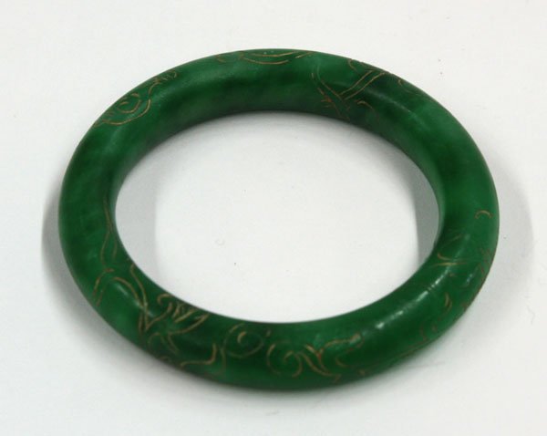 Chinese Green Jade Bangle Bracelet: Chinese jade bangle bracelet, the apple green mottled stone incised with gilt-filled chilong and a stylized shou character, 3''outer diam; 2.25''inner diam