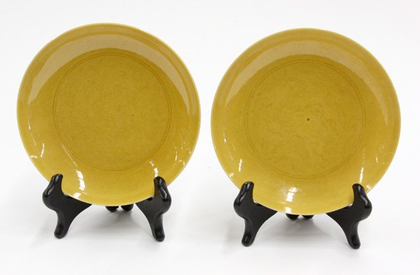 Chinese Yellow Monochrome Small Dishes: Pair of Chinese yellow monochrome glazed small porcelain dishes, each interior well faintly incised with a dragon roundel within a double ring, further dragons pursuing flaming jewels on the exterior