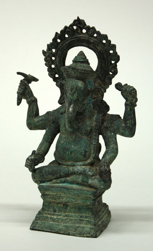 Southeast Asian Bronze Ganesa Figure: Southeast Asian bronze figure of Ganesa, Khmer, Angkor Wat style, the four-armed elephant-headed deity seated on a high square plinth, the anthropomophic figure wearing an ornate sampot, jewelery and 