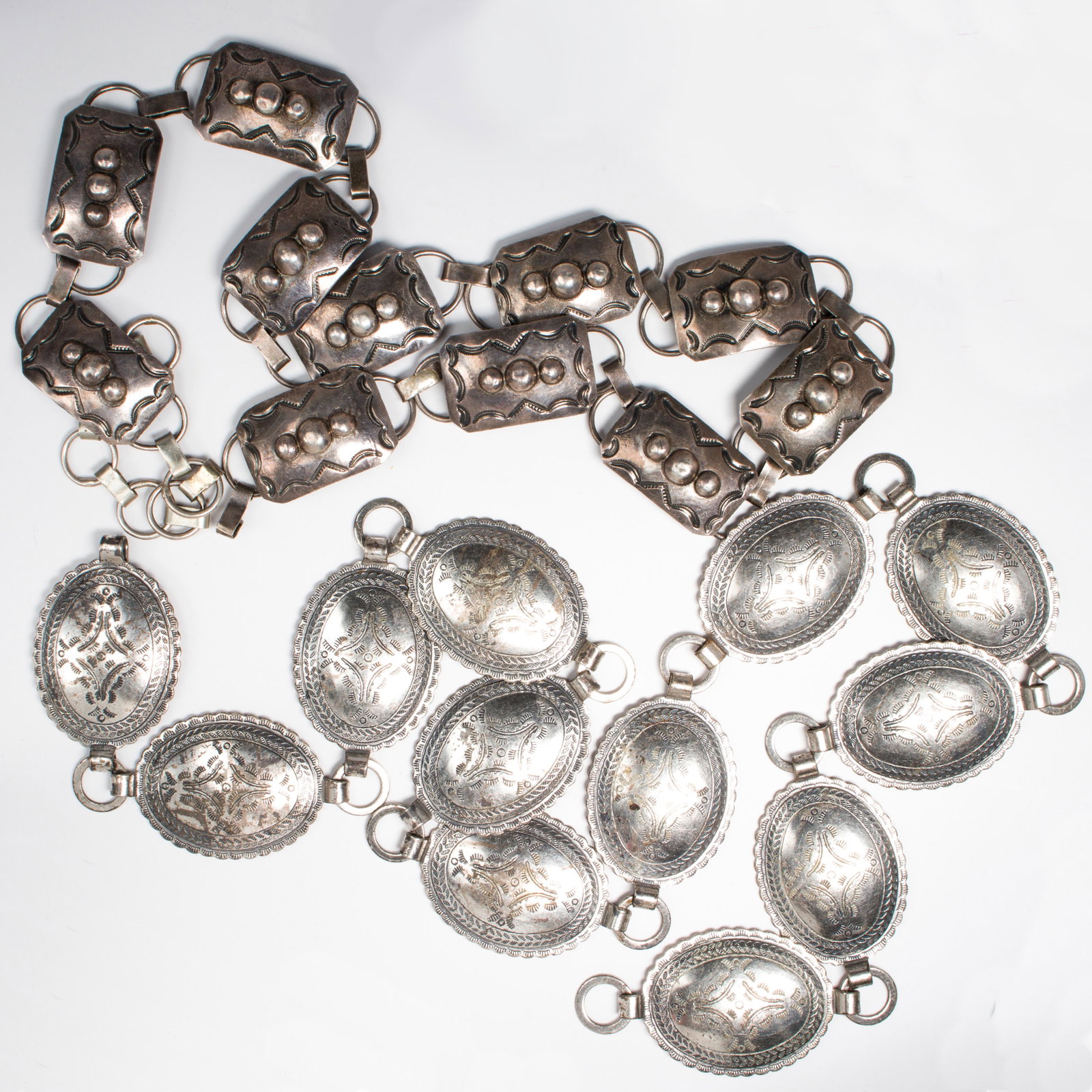 A group of silver and white metal belts: A group of silver and white metal belts including a silver belt composed of rectangular panels; A white metal belt composed of oval panels. Silver gross weight: 153.0 gs.