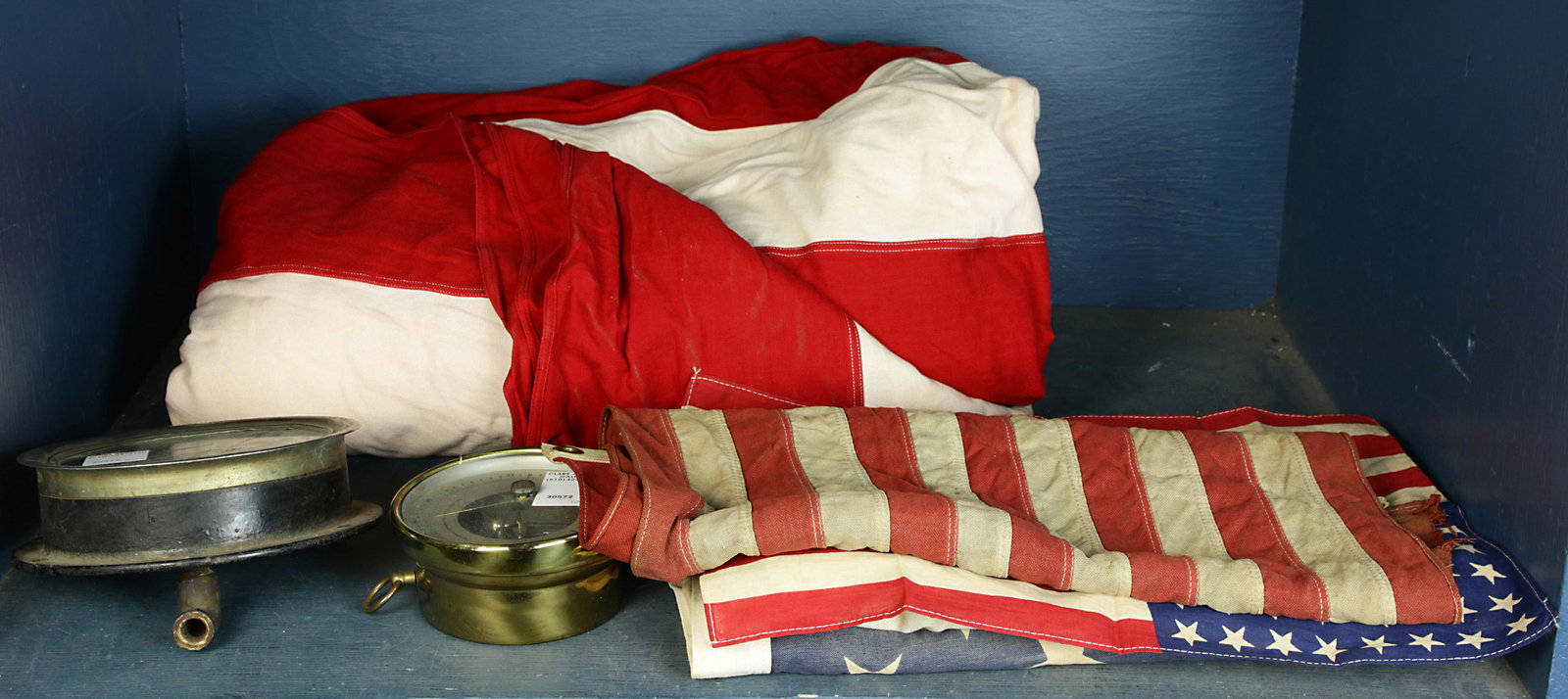 One shelf of Vintage flags including a California: One shelf of Vintage flags including a California example, and American flag examples in different sizes