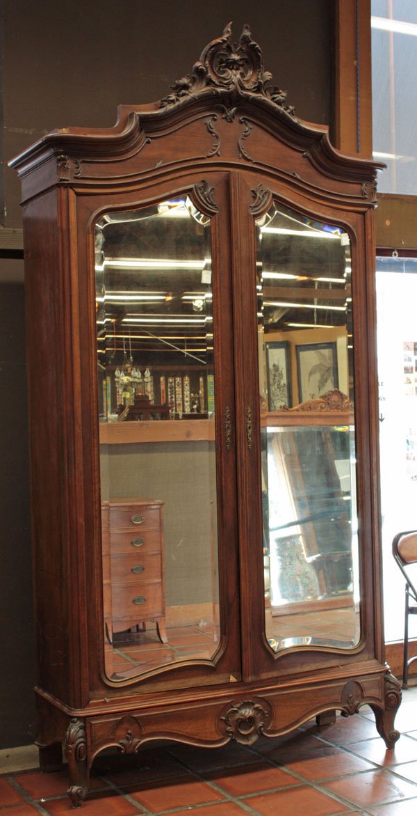 Louis XV style armoire: Louis XV style armoire having pierced rocaille crest above molded cornice, applied acanthus foliate relief surrounding beveled mirror double doors, with carved double bowed apron and resting on acanth