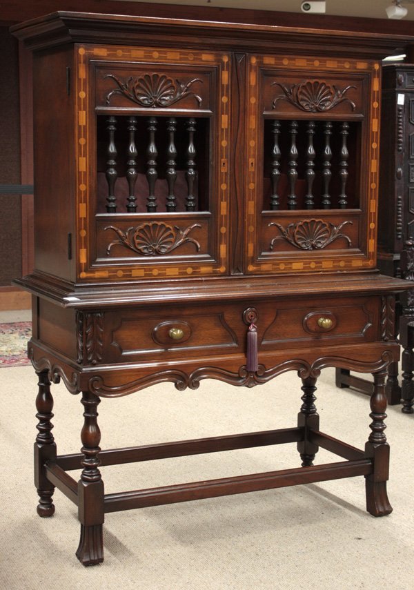 Cromwellian walnut china cabinet: Century Furniture Co., Grand Rapids, Cromwellian walnut china cabinet, with molded cornice above double doors centered with shell carved relief, with ebonized and turned split spindle panels having ge