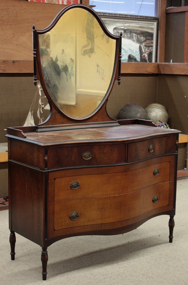 Berkey & Gay Federal style chest: Berkey & Gay Federal style chest of drawers having a shield form mirror and turned, ebonized wood accents, with reverse serpentine front, enhanced with beading and oval brasses, rising on tapered legs