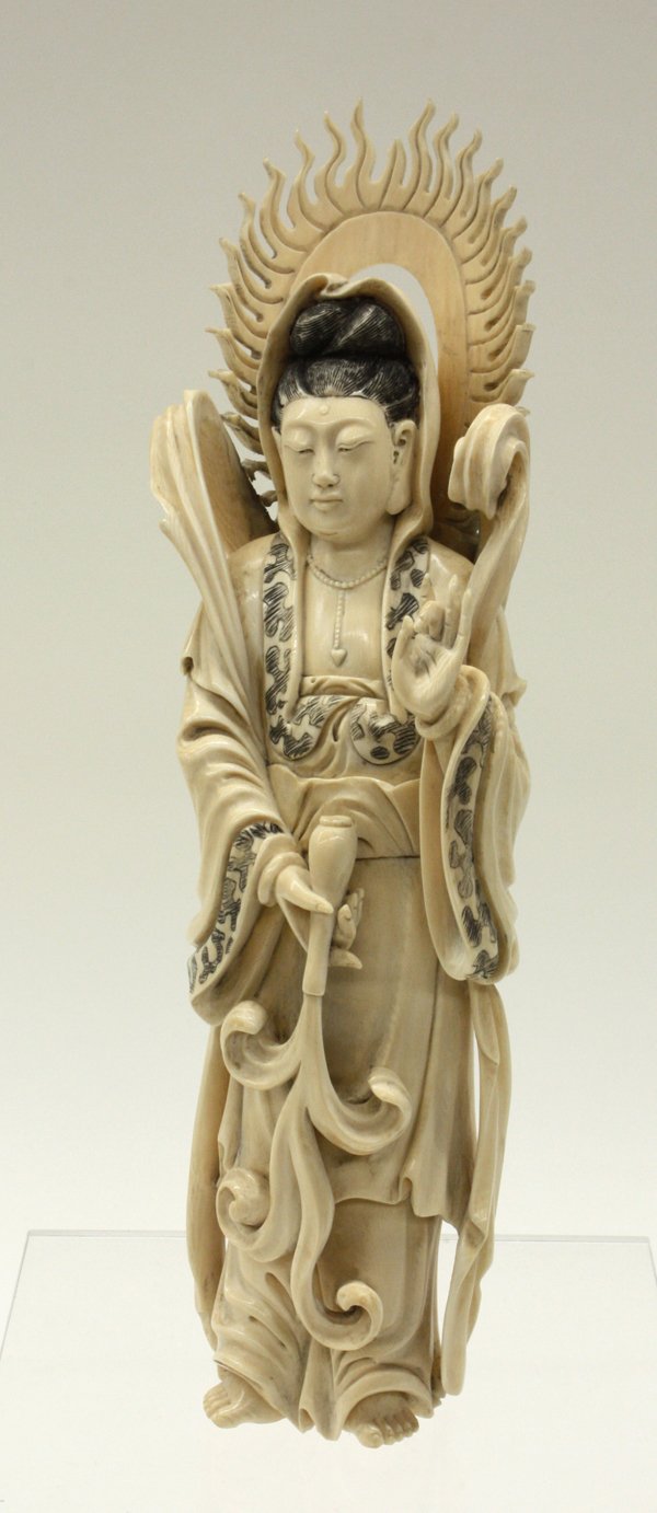 Chinese Ivory Guanyin Figure: Chinese ivory figural carving, depicting White-robed Guanyin standing in bodhisattva raiment with the left hand in the gesture of assurance, the other holding an upturned amphora issuing plumes of eli