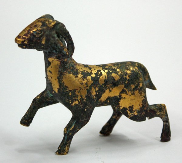Han-style Gilt Bronze Ram Figurine: Chinese gilt bronze figurine of a ram, possibly Han dynasty, depicted in mid-stride with its head to the front (evidence of test sample, possible repair to back leg, good patina), 3.5''l