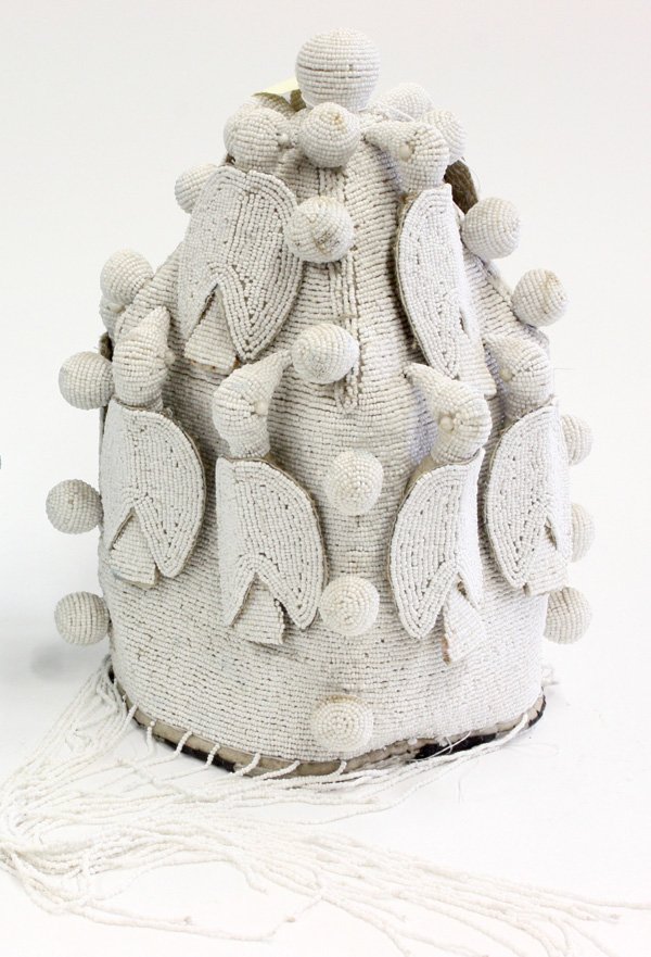Beaded ceremonial crown Yoruba Nigeria: (lot of 2) Beaded ceremonial crowns, Yoruba tribe, Nigeria, conically shaped in white on white and sky blue designs with spherical and avian elements, long beaded fringe, the larger 13''h x 9''w x 9''