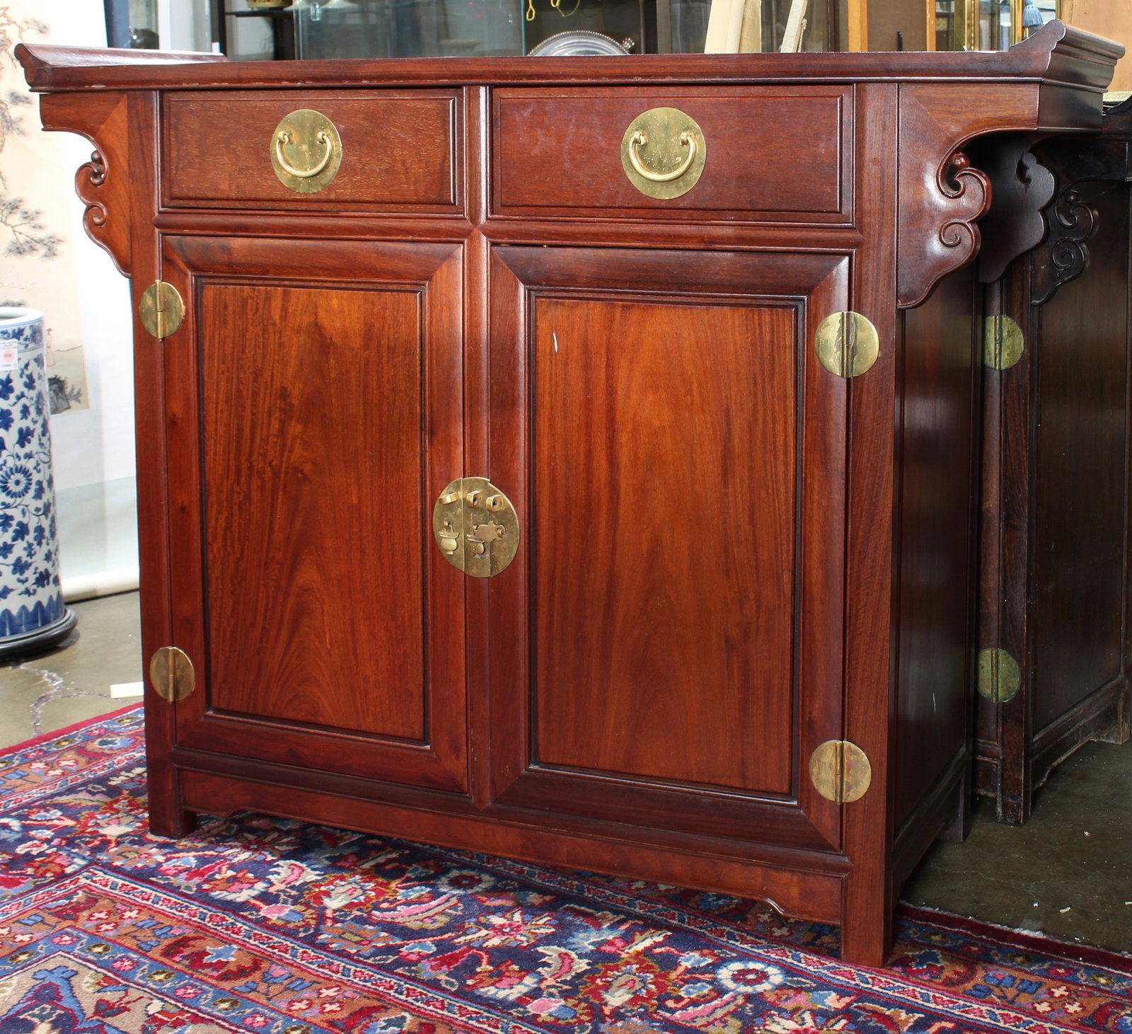 Chinese rosewood altar coffer: Chinese rosewood altar coffer, the rectangular top terminating in inverted flanges above spandrels, over two side by side drawers and twin cabinet doors, 34"h x 46"w x 14"d