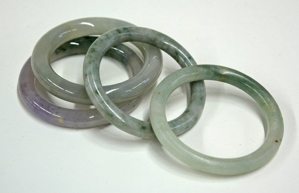 Chinese Jade/Jadeite Bangle Bracelets: (lot of 4) Chinese jade and jadeite bangle bracelets, each without decorative carving, one with lavender and dark green inclusions, others of mottled green color, 2.75-3.00''diam (outer)
