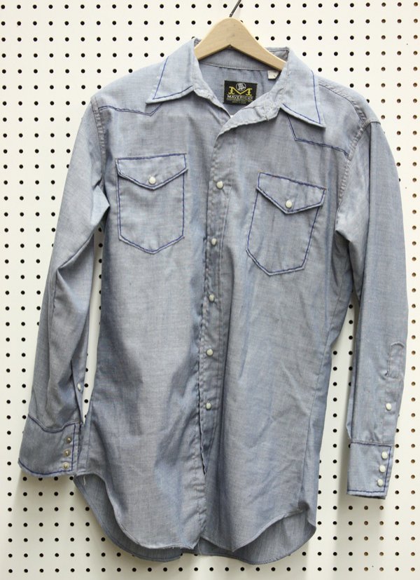 Vintage clothing, Merv Griffin: Vintage light blue santorized cowboy shirt with pearl style snaps and dark blue contrast stitching, the back adorned with embroidery of a shamrock and a United States flag heart, reading 'M G/America'