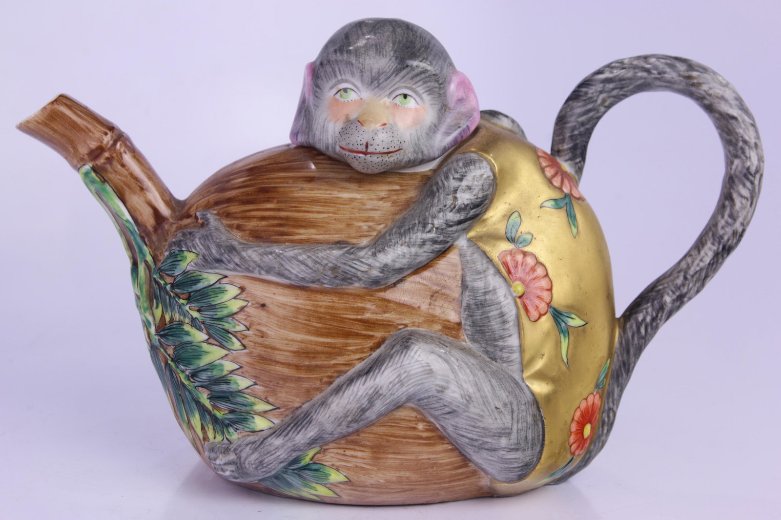 A French porcelain figure tea pot: A French porcelain figure tea pot, in the form of a monkey grasping a coconut, 6"h