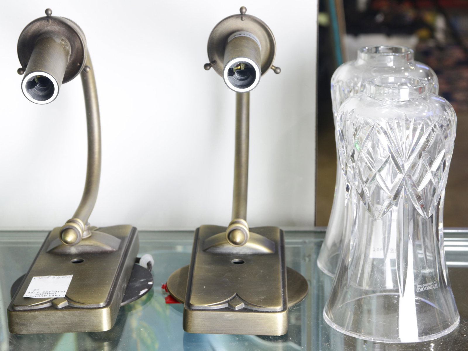 A pair of Waterford for Lighting One sconces: A pair of Waterford for Lighting One sconces, each having a hurricane style shade, above brass hardware, 13"h