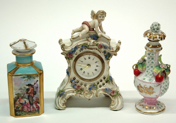 Porcelain German clock, scent bottle: (lot of 3) Porcelain items consisting of a German clock with putti, a stoppered schneeballen scent bottle with cherries, flowers and gilt accents, and a square stoppered scent bottle having decal deco