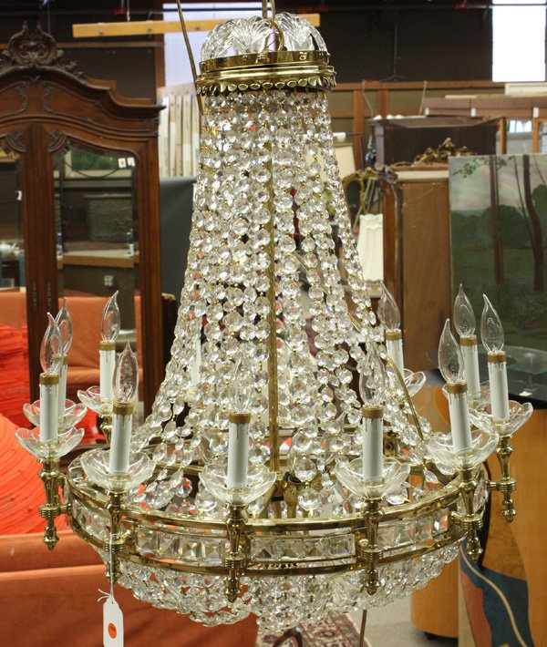 Modern brass 18-light chandelier: Modern brass 18-light chandelier having 12 exterior candle lights with 6 interior and a waterfall of crystals from upper to lower tier, 48''h to ceiling mount, 26''d