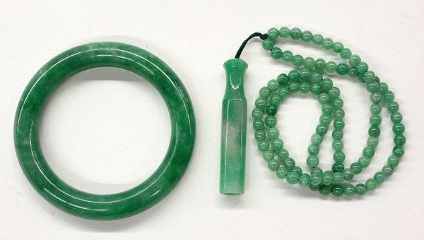 Chinese Jade Bangle and Ornaments: (lot of 2) Chinese jade decorations, consisting of one jade bangle bracelet of a semi-translucent green matrix suffused with light and dark inclusions, 3.25'' [outer diam], 2.5''[inter diam]; and a ch