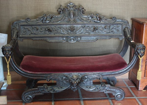 partial gilt and patinated bronze chandelier: Renaissance revival fine carved wood settee, 19th century, ''X'' form with ornate carved cartouche crest over foliate scroll, with open arms ending in gargoyle face, raised on splayed supports, 41''h 
