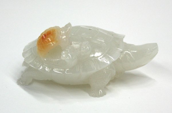 Chinese Jadeite Turtle Figurine: Chinese jadeite turtle group, probably 19th century, realistically carved and incised as a turtle walking with its head turned, a small turtle climbing on its shell and incorporating the single orange