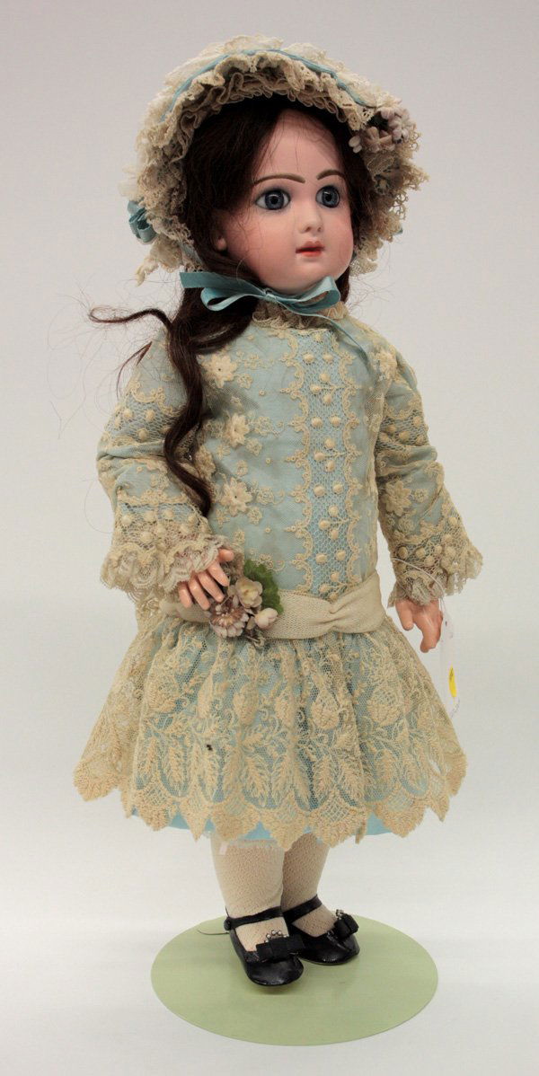 Vintage dolls: Antique bisque socket head doll with blue papwerweight eyes set in a hand decorated face having a closed mouth and pierced ears, on a jointed composition body appropriately dressed, 20''